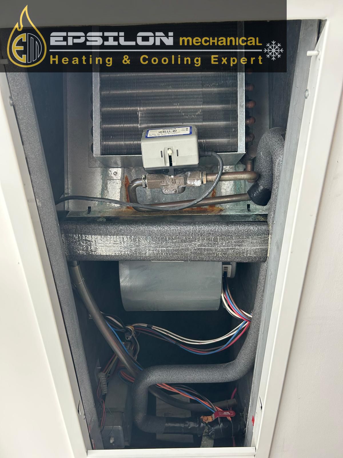 Epsilon Mechanical technician servicing a condo fan coil unit inside a Toronto high-rise suite