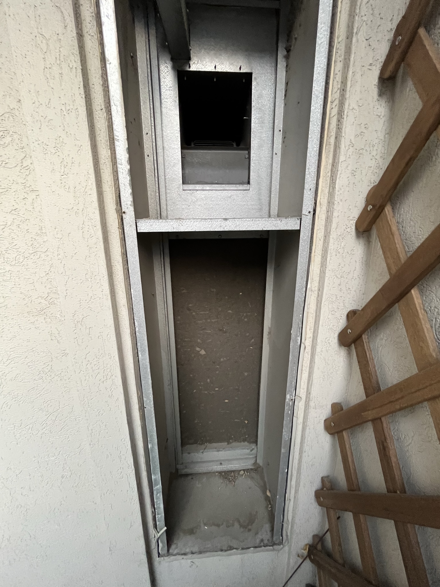 Empty through-the-wall AC sleeve with dust and debris visible inside a Toronto condo wall