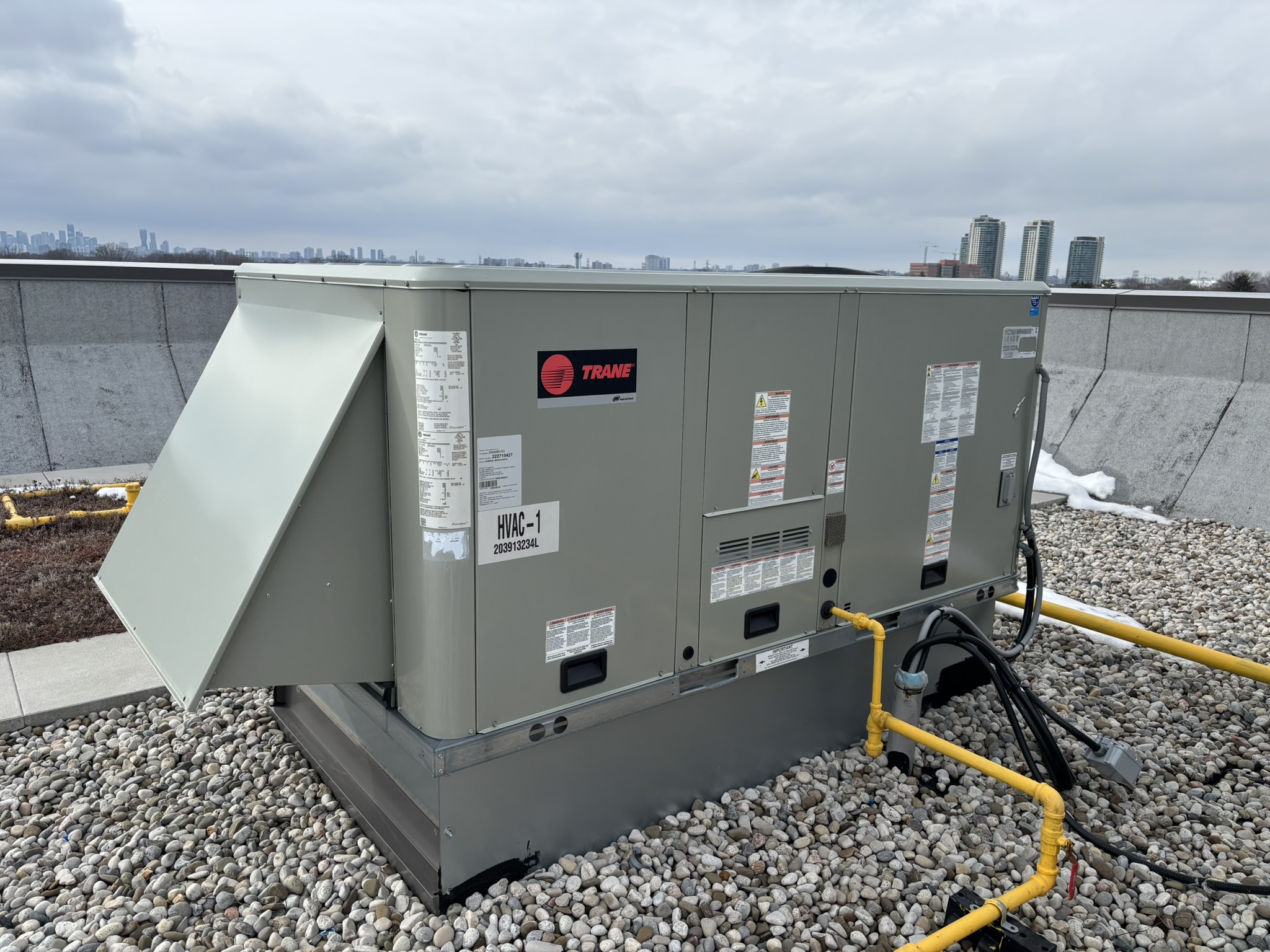 Trane commercial rooftop unit serviced by Epsilon Mechanical with Toronto skyline in background